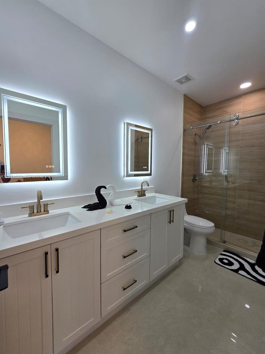 1680 Southwest 154th Path Miami, FL 33185 - Photo 28 of 100 a bathroom with a double vanity sink toilet mirror and bathtub