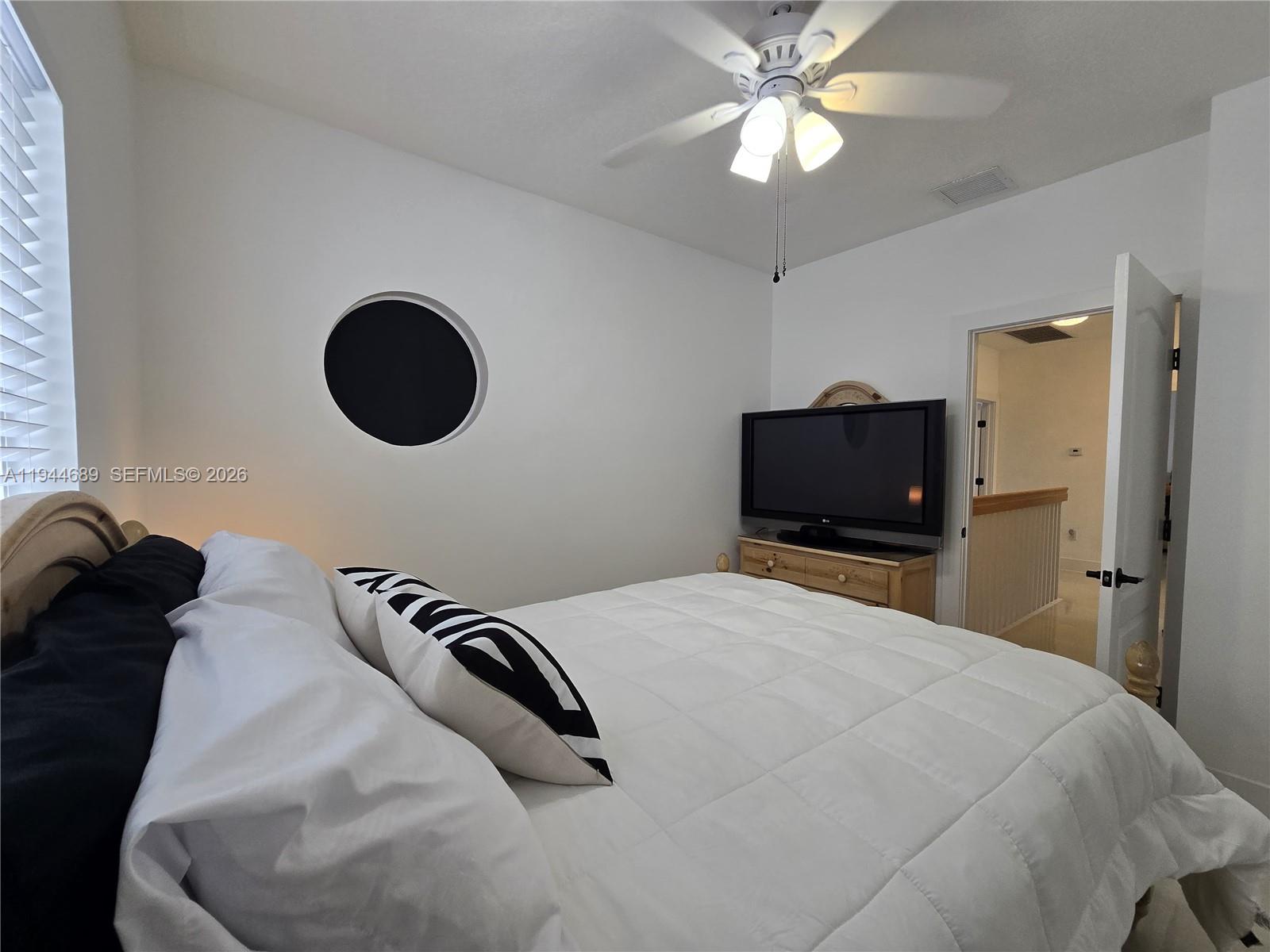 1680 Southwest 154th Path Miami, FL 33185 - Photo 67 of 100 a bedroom with a bed and a chandelier