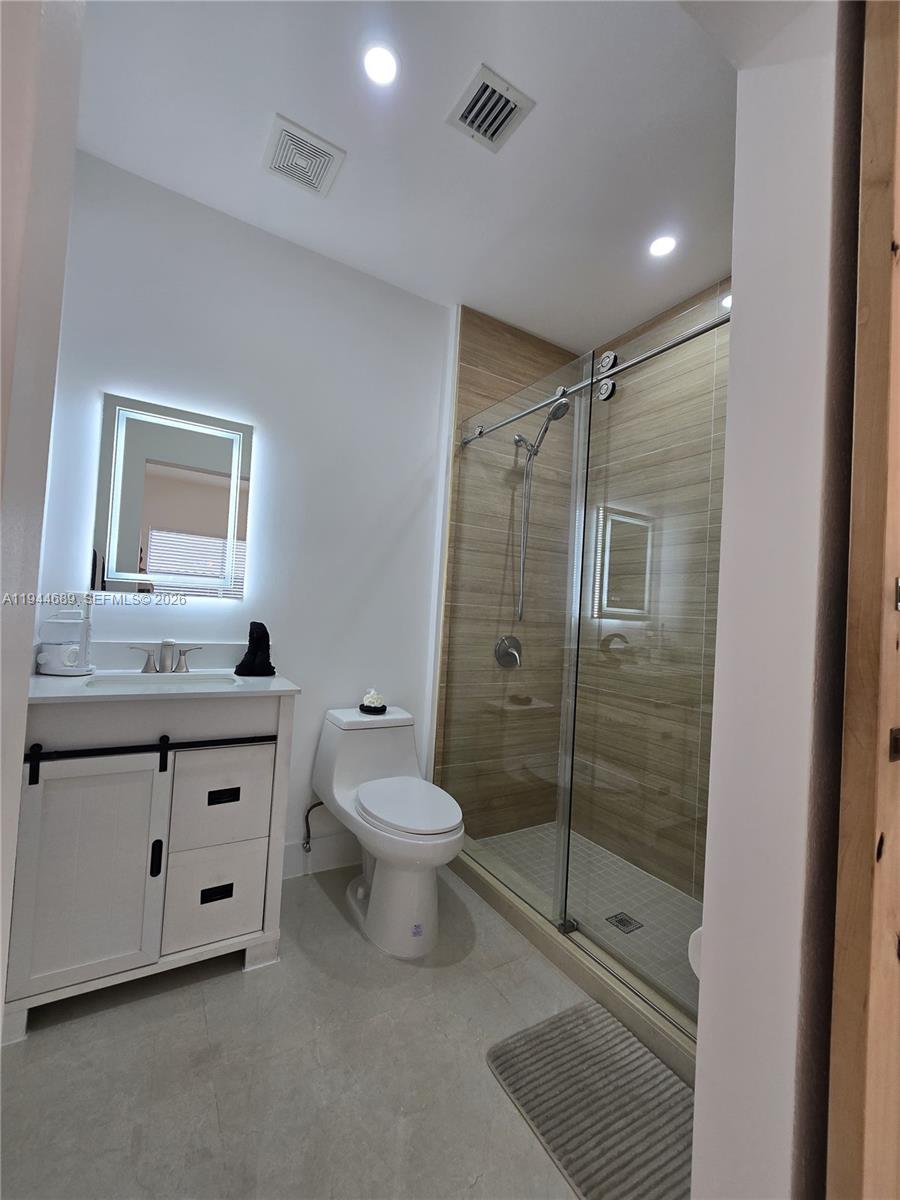 1680 Southwest 154th Path Miami, FL 33185 - Photo 80 of 100 a bathroom with a granite countertop sink mirror vanity and toilet