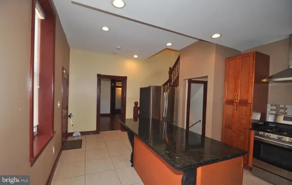 a kitchen with stainless steel appliances granite countertop a refrigerator a stove and a sink