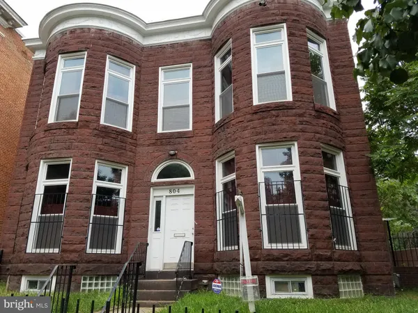 a front view of a house with iron fence