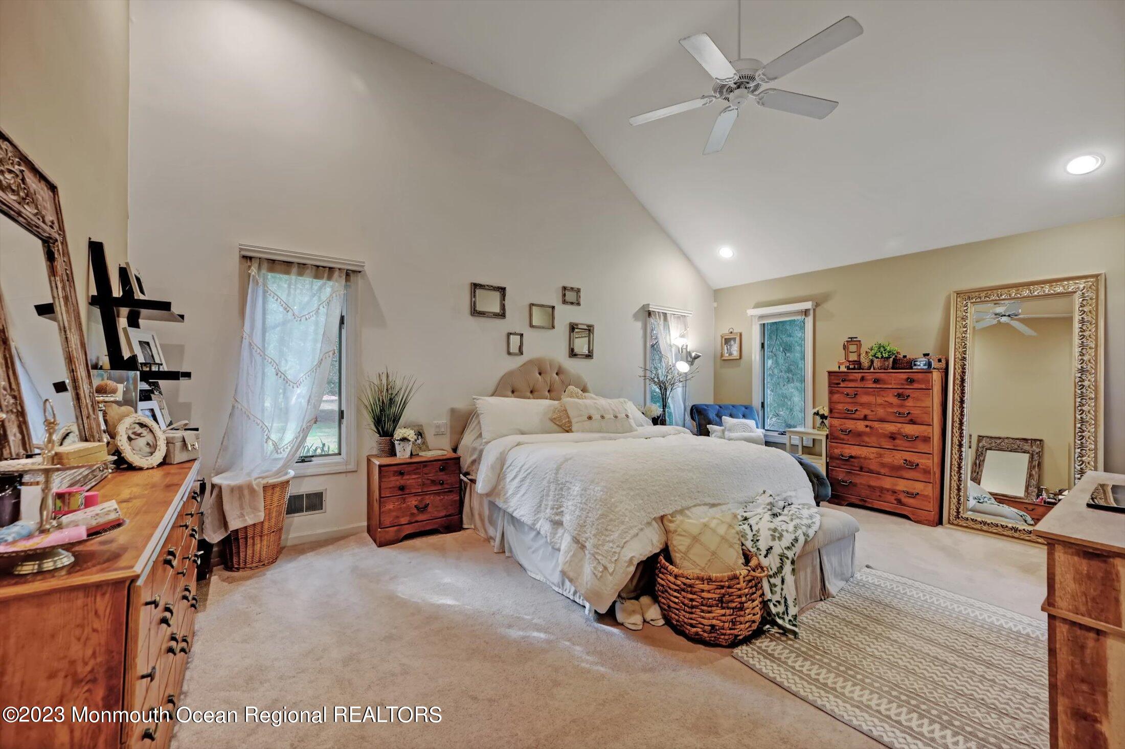 897 Fort Plains Road Howell, NJ 07731 - Photo 10 of 35 a bedroom with a large bed and a chandelier