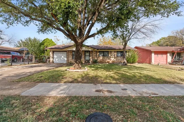 a front view of a house with a yard and palm trees