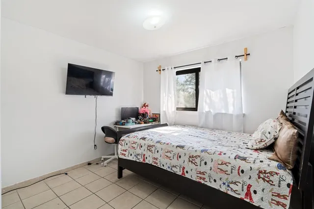 a bedroom with a bed and a flat screen tv