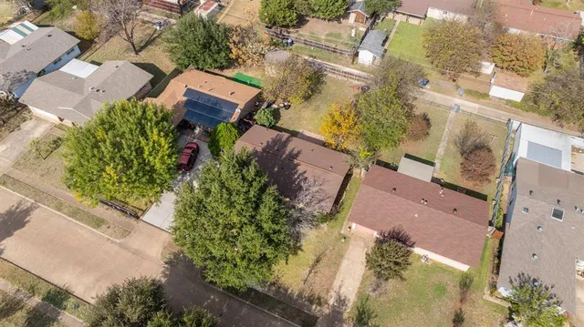 an aerial view of a house with a yard and trees