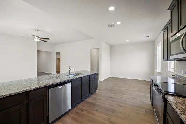 a kitchen with stainless steel appliances granite countertop a sink and stove