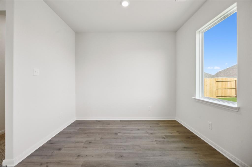 9908 Fighting Falcon Way Fort Worth, TX 76131 - Photo 15 of 22 a view of an empty room with wooden floor and a window