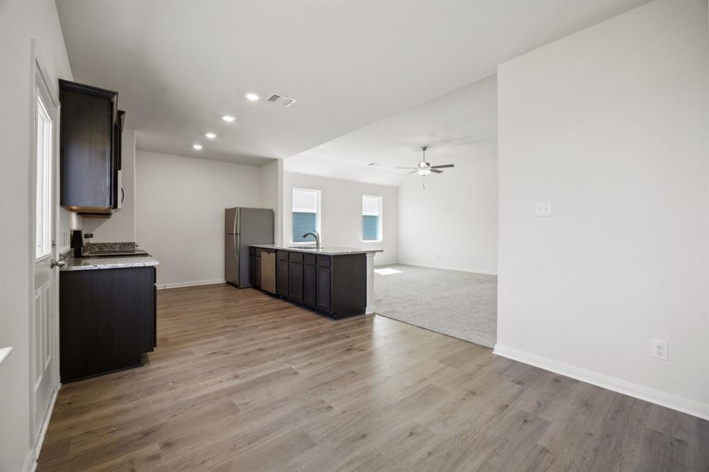 9908 Fighting Falcon Way Fort Worth, TX 76131 - Photo 22 of 22 a view of kitchen and empty room with wooden floor