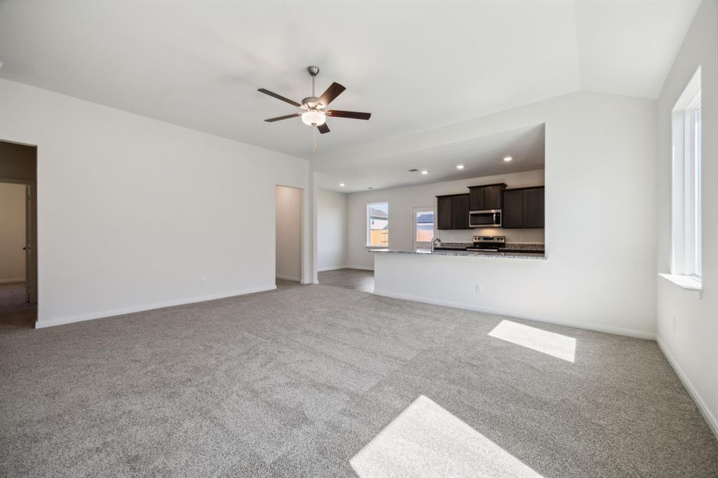 9908 Fighting Falcon Way Fort Worth, TX 76131 - Photo 8 of 22 a view of a livingroom with kitchen furniture and a ceiling fan
