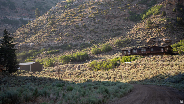 7500 Spring Canyon Road Helper, UT 84526 - Photo 1 of 64 Hillside property featuring a multi-level residence with a wood-clad exterior and multiple windows