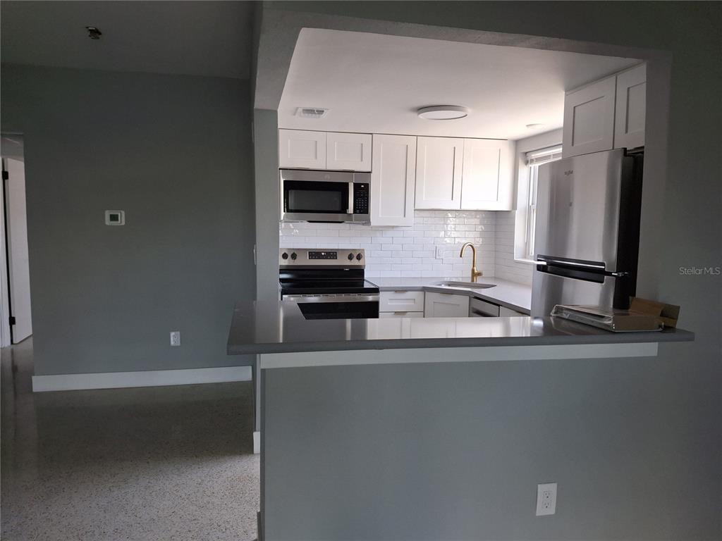 11355 3rd Street East Treasure Island, FL 33706 - Photo 2 of 19 a kitchen with stainless steel appliances a sink a stove and a refrigerator