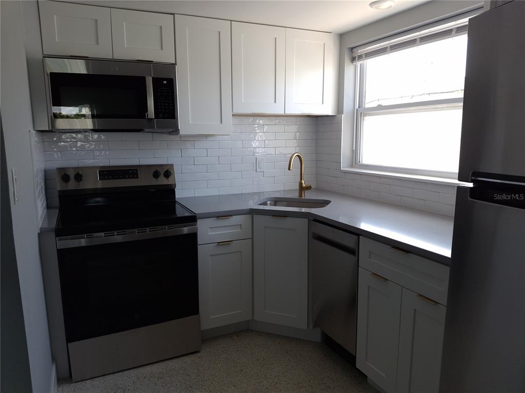 11355 3rd Street East Treasure Island, FL 33706 - Photo 4 of 19 a kitchen with a sink stove and microwave