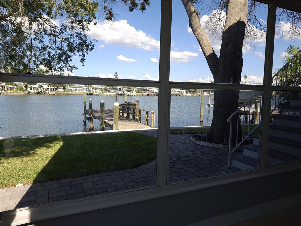 11355 3rd Street East Treasure Island, FL 33706 - Photo 8 of 19 a view of a balcony with floor to ceiling windows wooden floor and a table and chairs