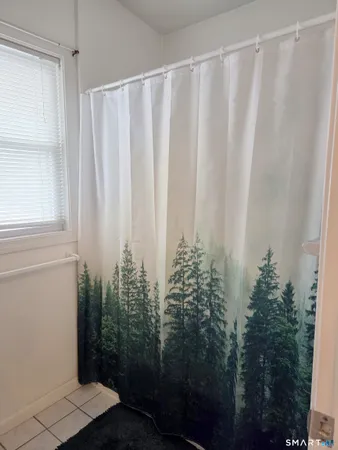 a bathroom with a shower curtain and a window