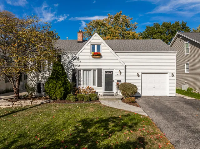 a view of a house with backyard and sitting area