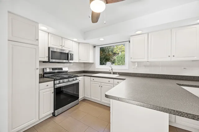 a kitchen with cabinets stainless steel appliances and window