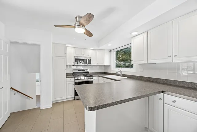 a kitchen with kitchen island a stove cabinets and a refrigerator
