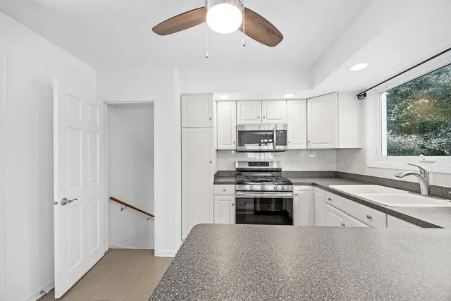 a kitchen with stainless steel appliances granite countertop a stove a sink and a refrigerator