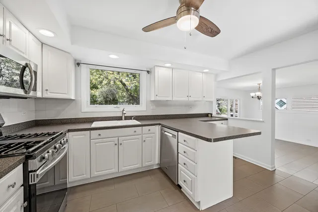 a kitchen with granite countertop stainless steel appliances a sink and cabinets