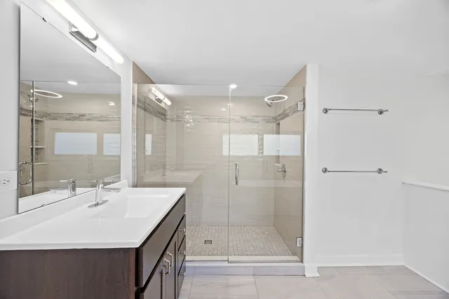 a bathroom with a shower a sink and a mirror