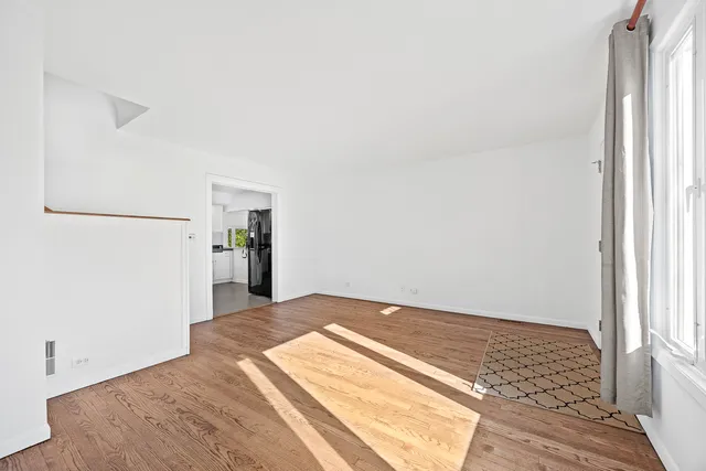 a view of a bedroom with wooden floor and a hallway