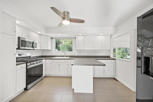 a kitchen with granite countertop white cabinets and white appliances