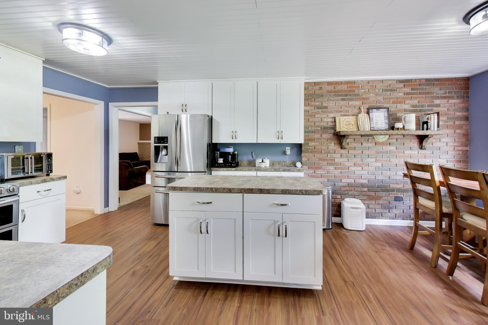 3240 Juniper Lane Huntingtown, MD 20639 - Photo 39 of 48 a kitchen with stainless steel appliances granite countertop a white cabinets and wooden floor