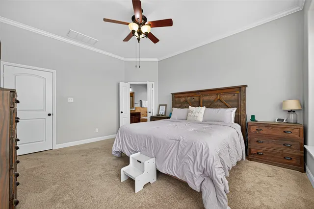 a bedroom with a bed a chandelier and a flat tv screen