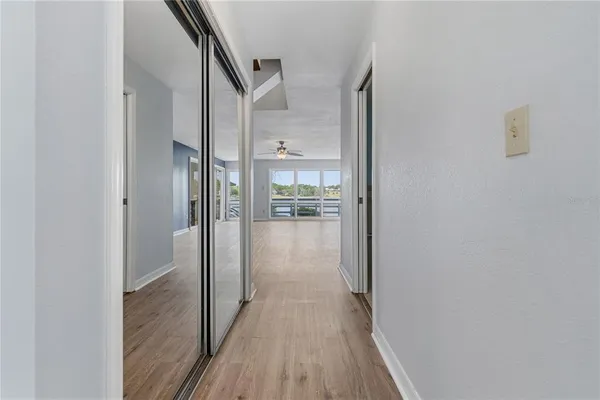a view of a hallway with wooden floor and a glass door