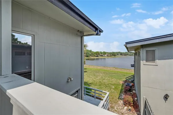 an empty room with wooden floor mirror and windows