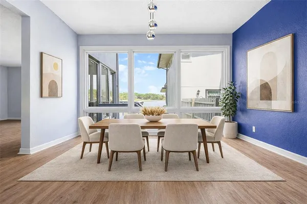 a dining room with wooden floor a chandelier a wooden table and chairs