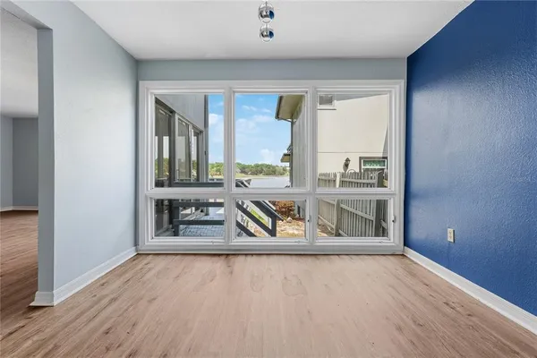 an empty room with large window and wooden floor