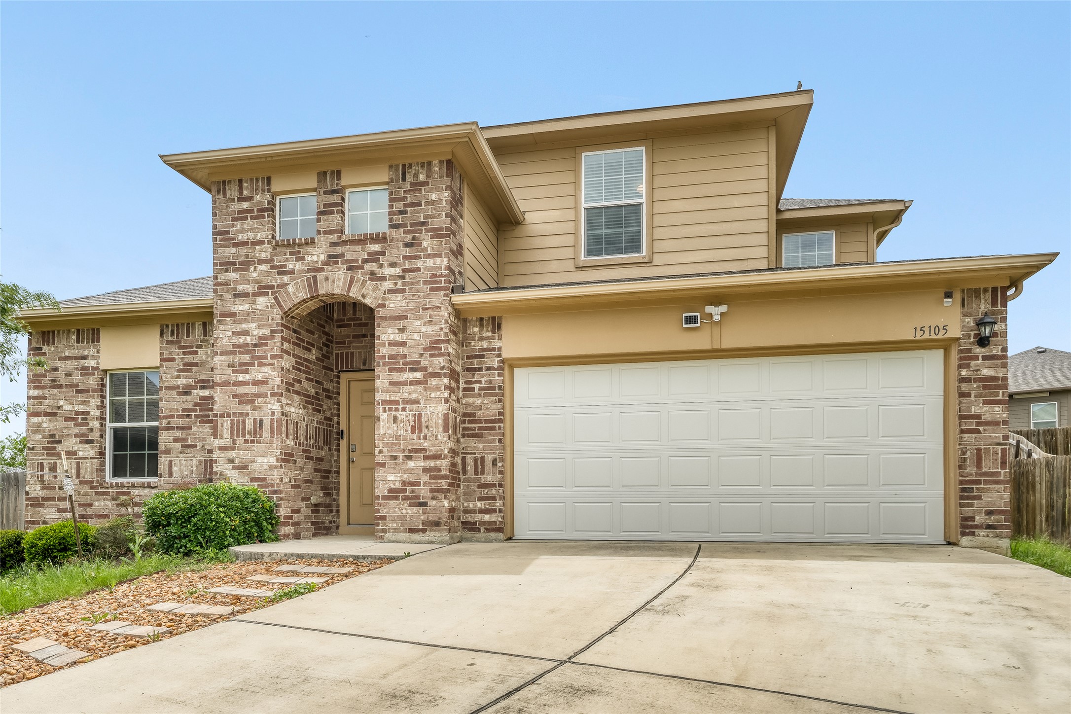 15105 Shell Bark Cove Austin, TX 78724 - Photo 2 of 30 A welcoming facade showcases a combination of brick and siding, complemented by an integrated garage and arched entryway.