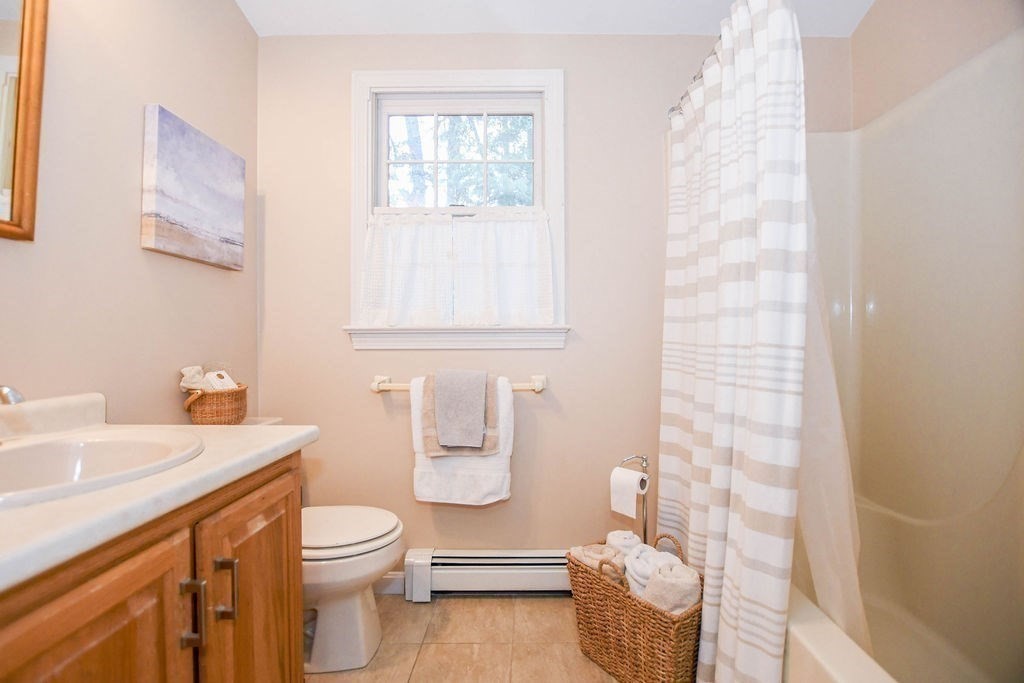 12 Forster Road Rochester, MA 02770 - Photo 29 of 42 a bathroom with a sink a toilet and shower curtain