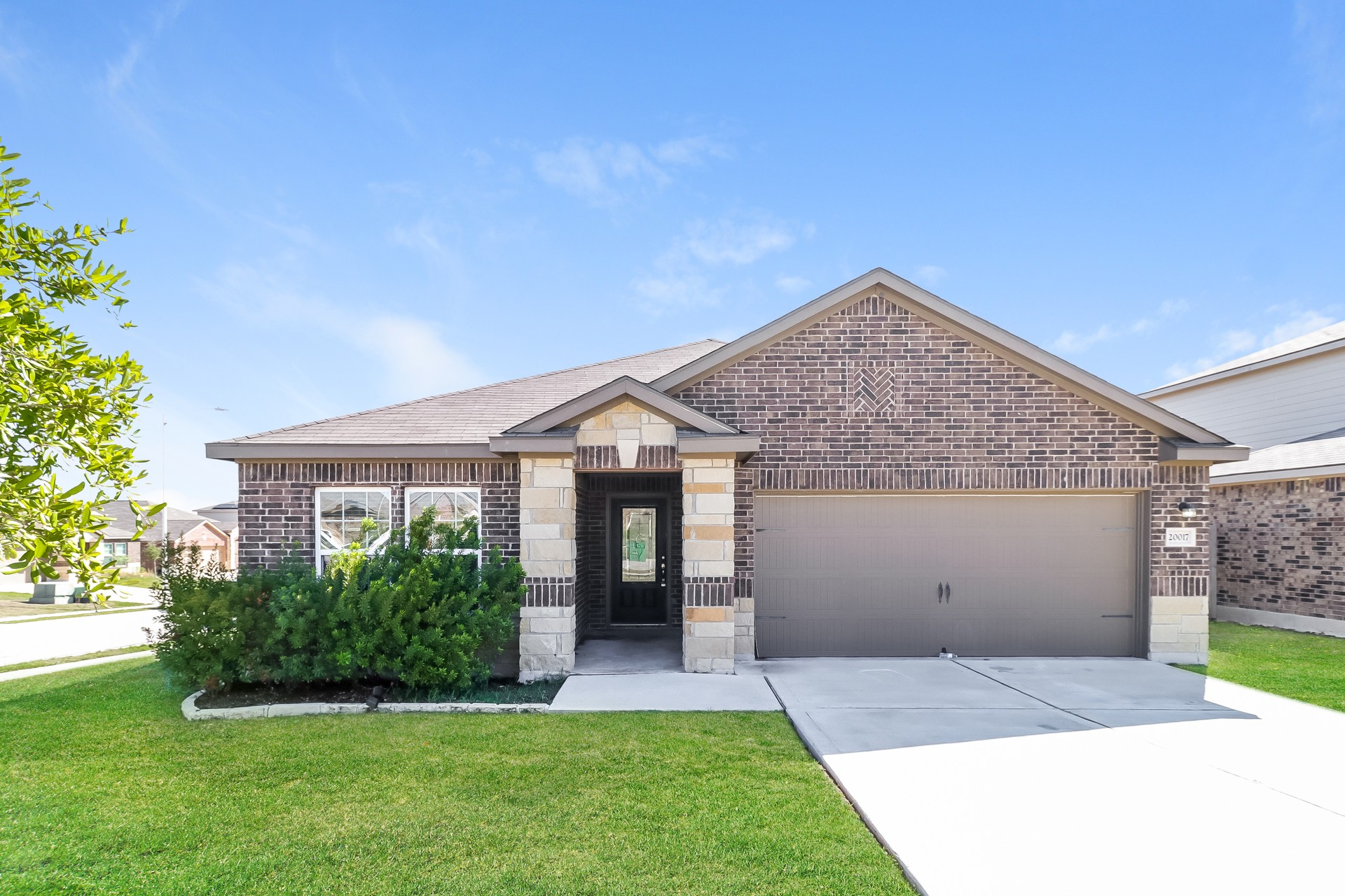 20017 Hubert R Humphrey Road Manor, TX 78653 - Photo 1 of 27 A well-maintained facade features a mix of brick and stone, welcoming residents and guests alike.