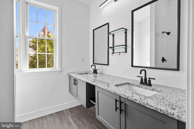a bathroom with a granite countertop sink and a mirror