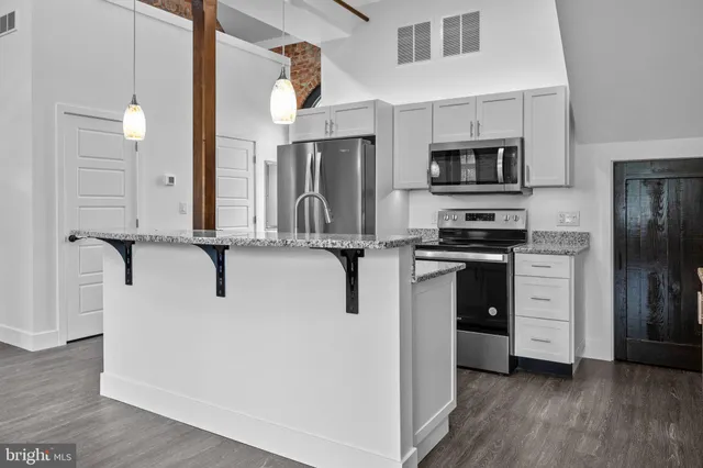 a kitchen with stainless steel appliances a refrigerator sink and stove