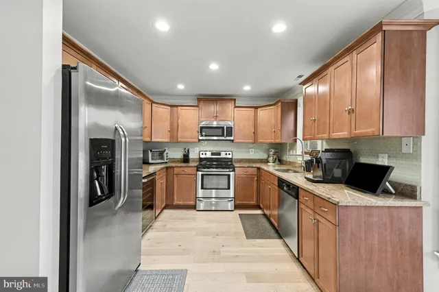 a kitchen with granite countertop a sink cabinets and stainless steel appliances