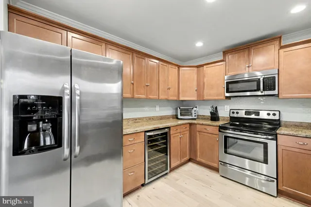 a kitchen with stainless steel appliances granite countertop white cabinets a sink and a stove