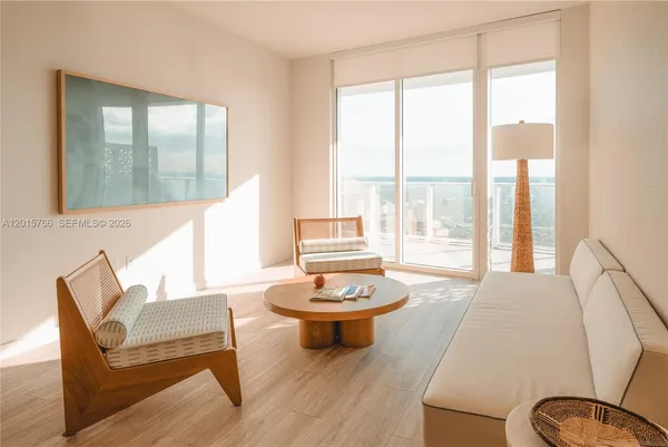 a living room with furniture a window and a potted plant