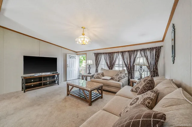 a living room with furniture a flat screen tv and a large window