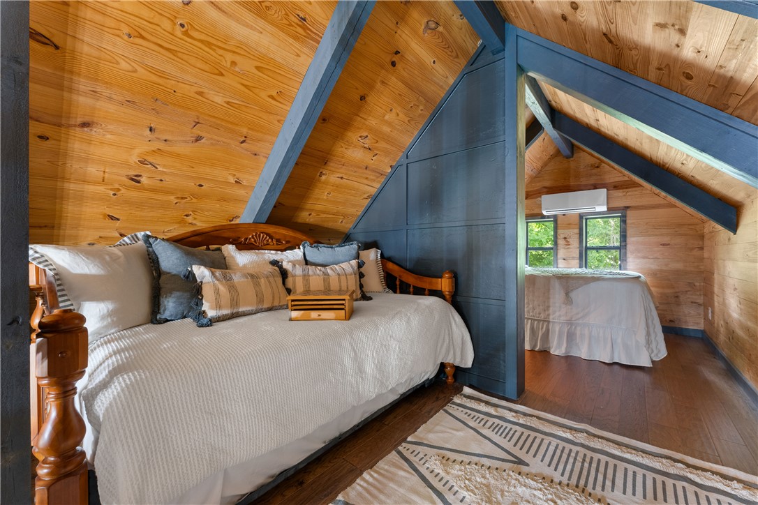 3931 Zack Road Marshall, AR 72650 - Photo 53 of 56 Bedroom with hardwood / wood-style floors, wood walls, and a wood ceiling with exposed beams