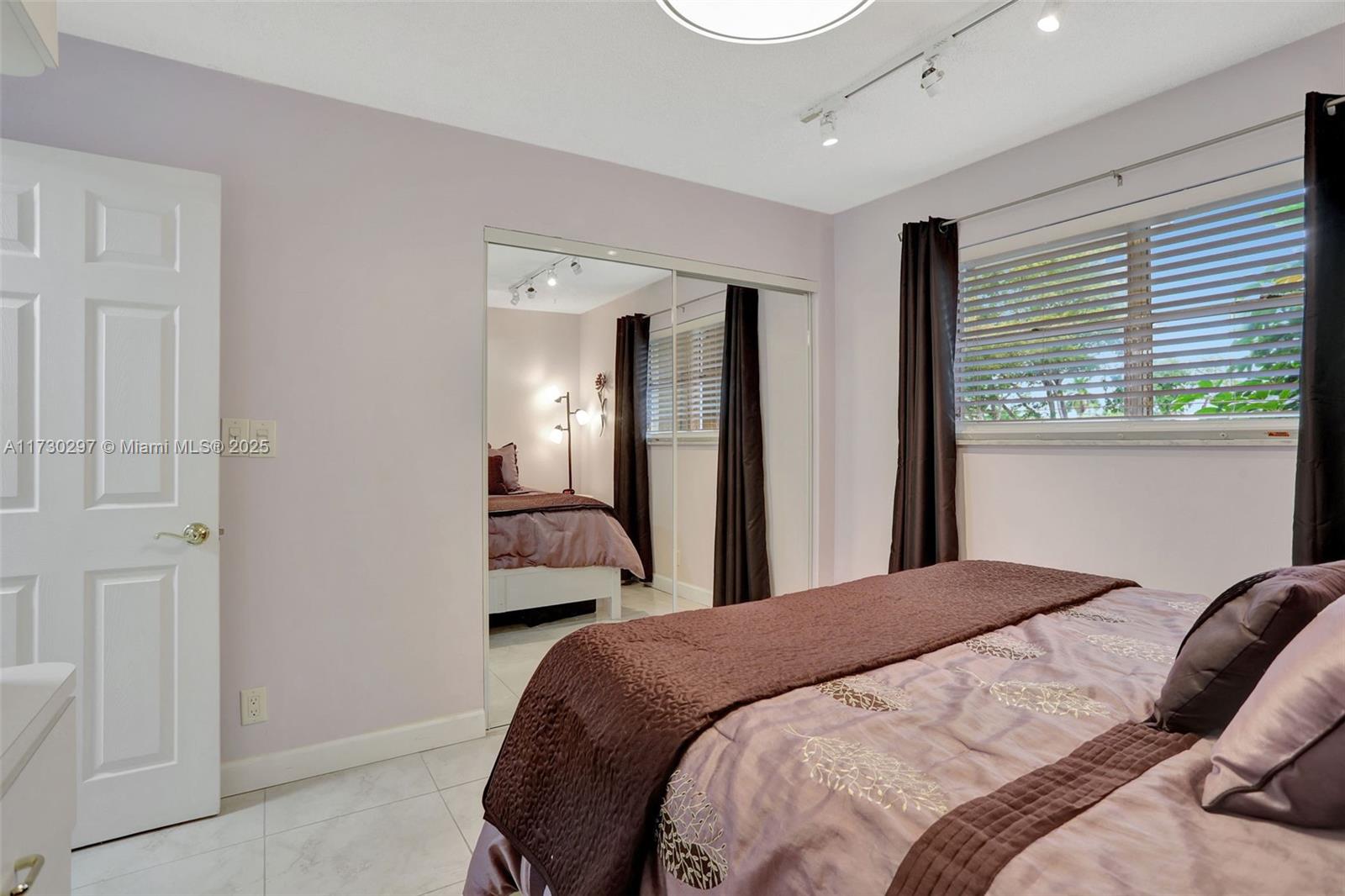 6080 Northwest 44th Street, Unit 212 Lauderhill, FL 33319 - Photo 21 of 44 a bedroom with a bed and a large mirror