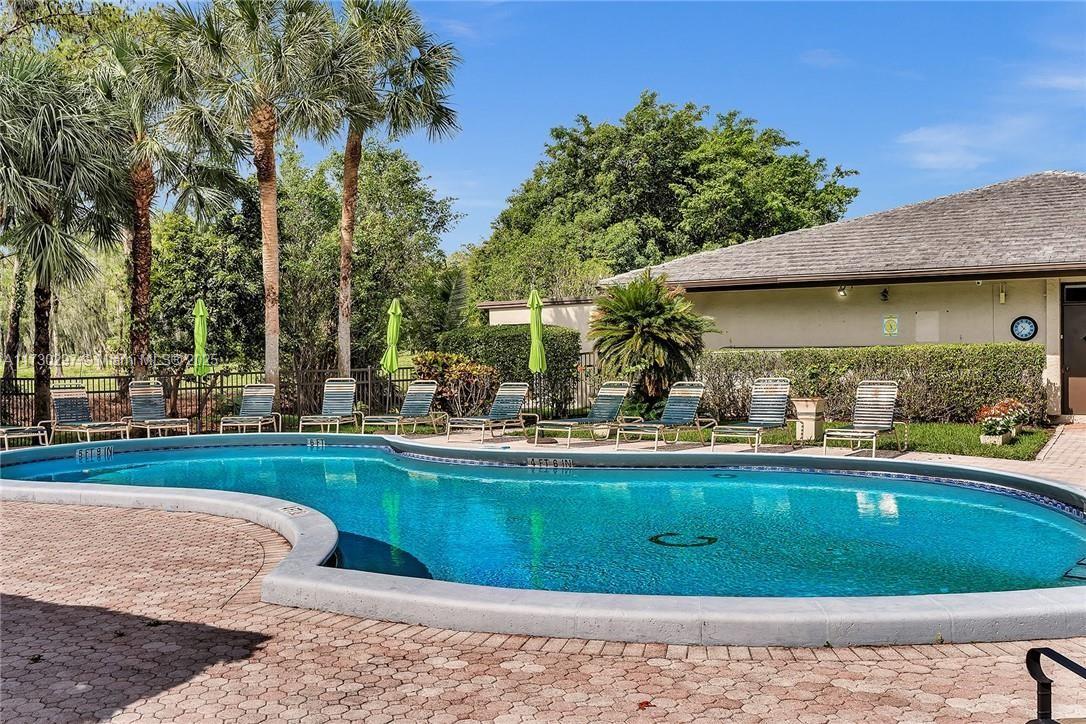 6080 Northwest 44th Street, Unit 212 Lauderhill, FL 33319 - Photo 32 of 44 a view of a swimming pool with a garden