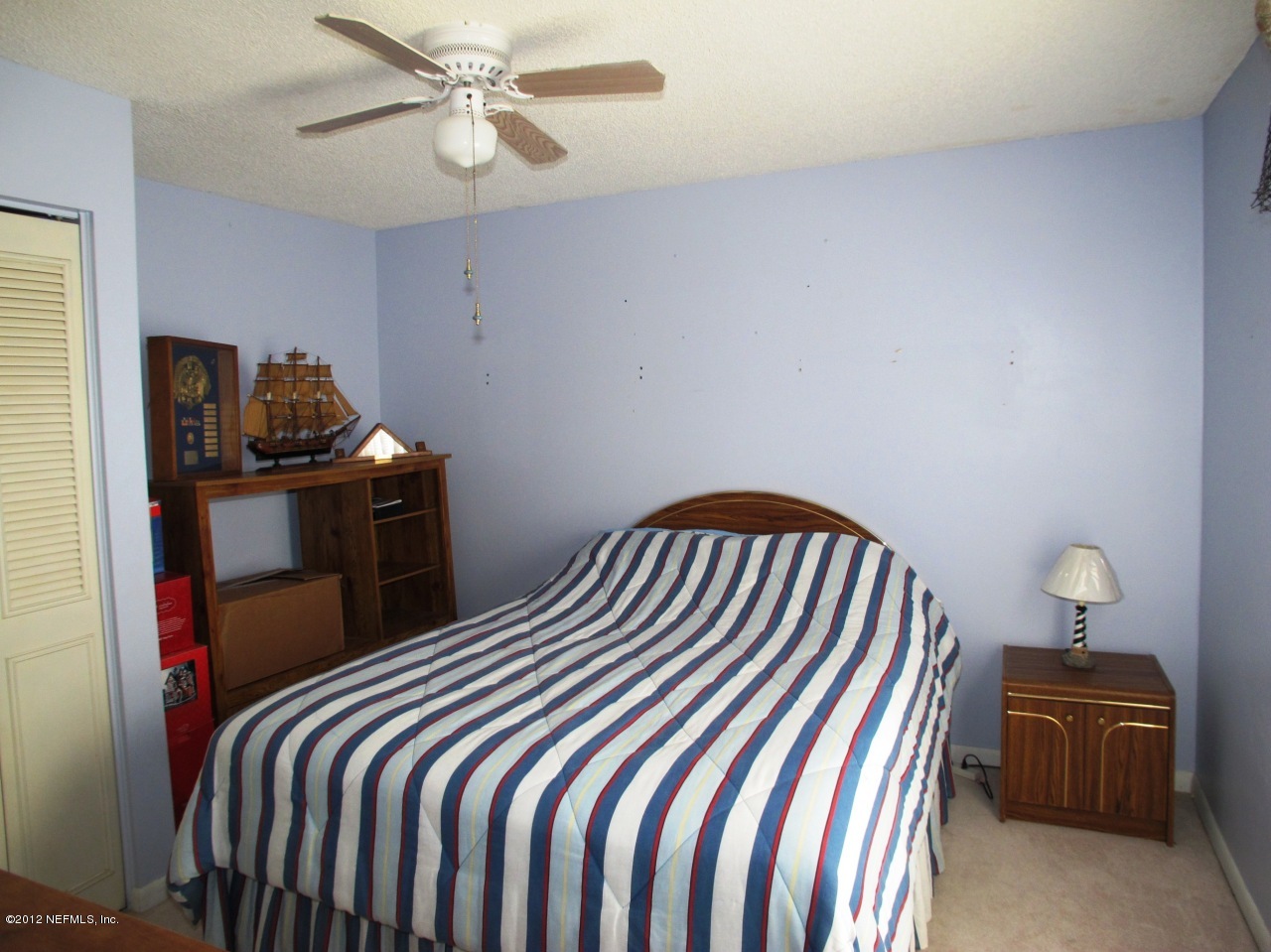 11745 Wattle Tree Road North Jacksonville, FL 32246 - Photo 10 of 18 a bedroom with a bed and a chandelier
