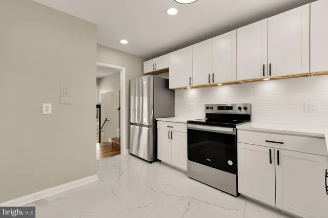 a kitchen with stainless steel appliances white cabinets and a refrigerator