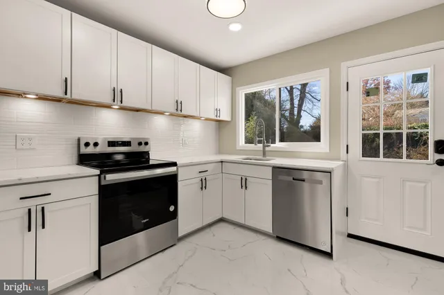 a kitchen with white cabinets stainless steel appliances and sink