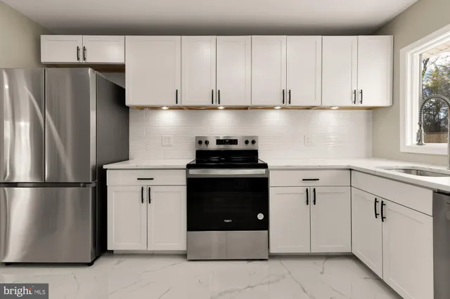 a kitchen with a refrigerator and white cabinets