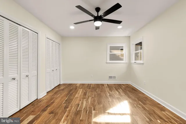 a view of a room with wooden floor and a ceiling fan