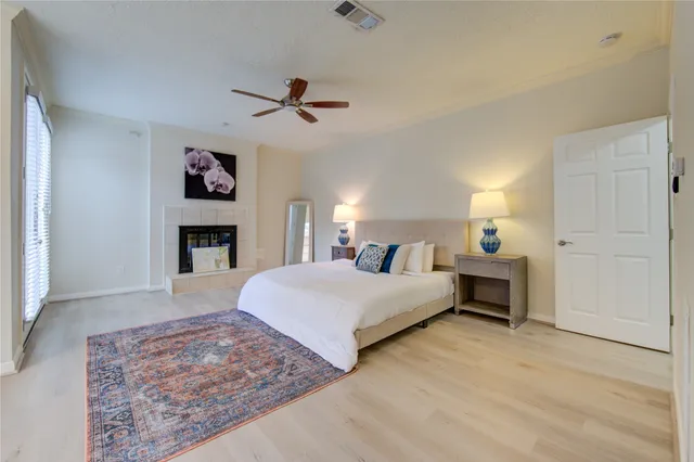 a bedroom with a bed dresser and a fireplace